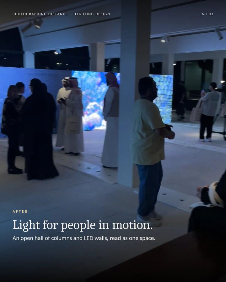 The gallery in use — Visitors moving through the open gallery between columns and LED displays.